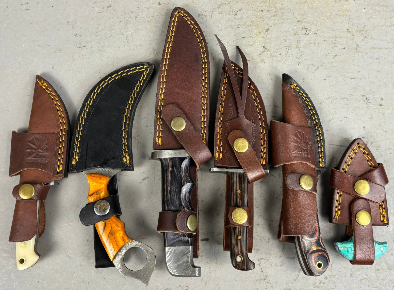 6 Hunting Knives Damascus Blades Leather Seaths: Great selection of 6 hunting knives damascus blades all in leather seaths. Sizes and conditions vary, sizes range from 5"x2.25" and largest is 10.75"x2". Please see pics for details on knives.