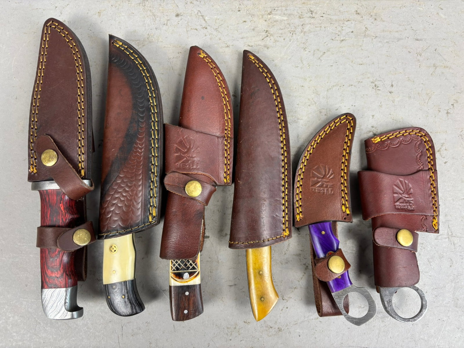 6 Vintage Damascus Blade Hunting Knives Seaths: Great selection of 6 hunting knives damascus blades all in leather seaths. Sizes and conditions vary, sizes range from 7"x3" and largest is 10.5"x2.25". Please see pics for details on knives.