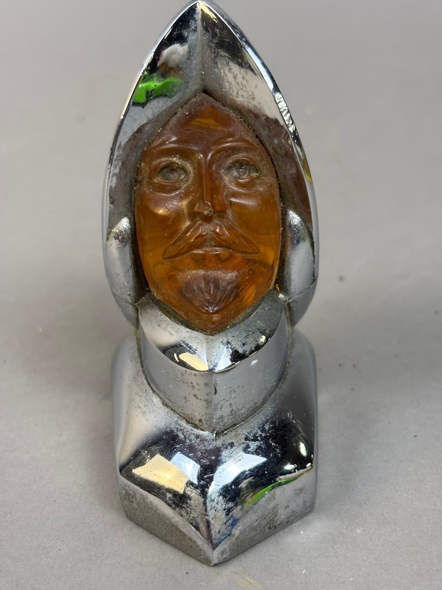 50s Era Desoto Lucite Face Viking Hood Ornament: This lot features a 50-52 Desoto Lucite Viking Face Hood Ornament. Minor pitting on chrome and face portion has some crazing. Overall measurements are 3.5"x2.5"x2". Please review all pictures for best