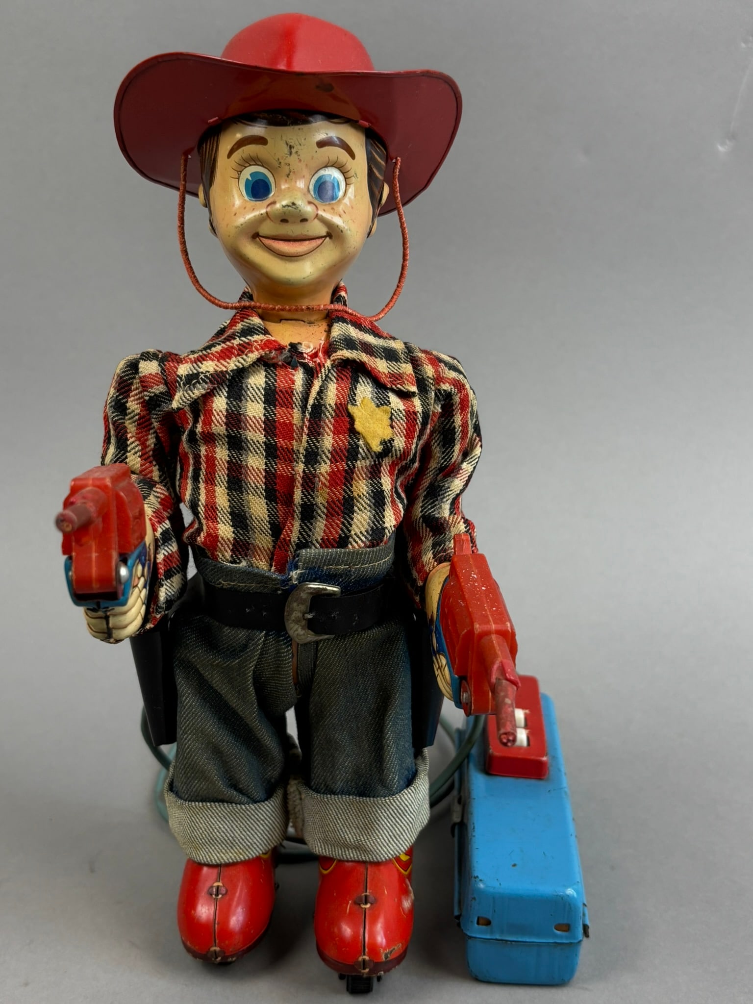 Yonezawa Wild Bill Cowboy Battery OP Tin Toy 2 Gun: This lot features a walking, shooting Yonezawa Marshall Wild Bill Cowboy battery operated remote control toy. Please review all pictures for best description, toy powers on, he shoots but does not wal