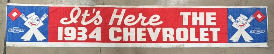 It's Here The 1934 Chevrolet Cloth Advertising Banner: Measures 208" x 24" - incredible condition overall - See all photos for a better idea on condition. All items are sold as-is, where-is! This is a simulcast auction event, with in house bidding offered