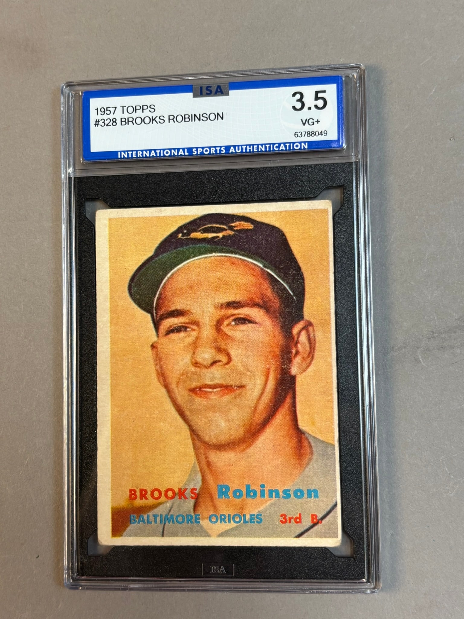 1957 Topps #328 Brooks Robinson RC HOF ISA 3.5 VG+ Very Good: ISA 3.5 Cert 63788049 PLEASE NOTE WE OFFER IN HOUSE SHIPPING & HAVE BIDDING AVAILABLE ON OUR OWN WEBSITE! If you win on LIVE AUCTIONEERS, please click "SELF ARRANGED SHIPPING" when you receive your in