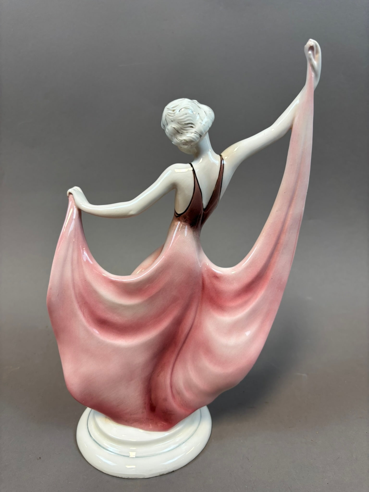 Katzhutte Art Deco 1920s Porcelain Dancing Lady Figure Dress Germany: Art Deco German porcelain figural sculpture depicting an elegant dancing lady with flowing dress dramatically extended in both hands, raised arms, and black high heels, mounted on a round pedestal bas