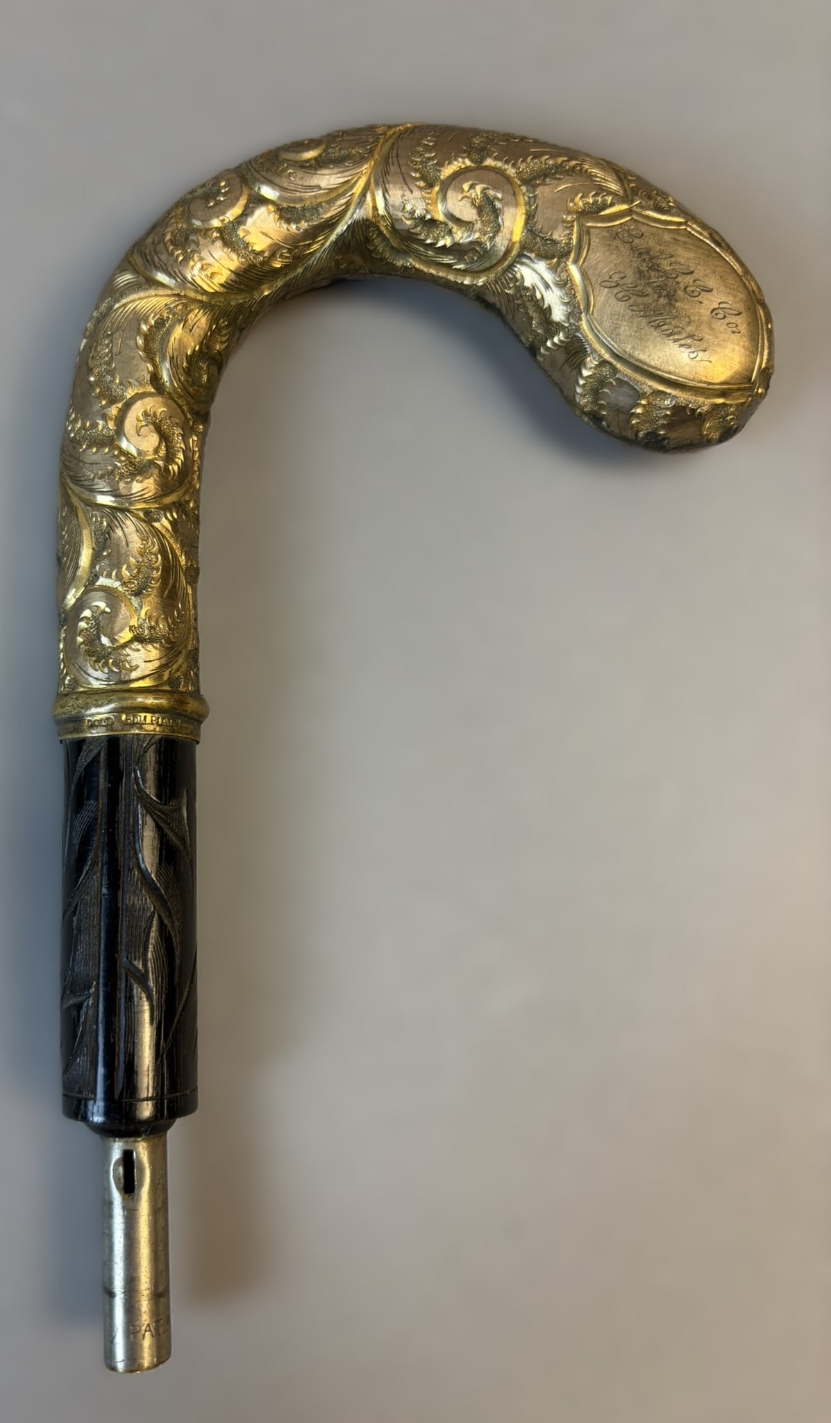Victorian Carved Horn Cane Handle w/ Gold Roll Plate Engraving: Decorative carved horn cane handle measuring approximately 7" x 4" x 0.75". The handle features intricate scrolling and foliate motifs with a rich gold plated finish, marked “GOLD ROLL PLATE.