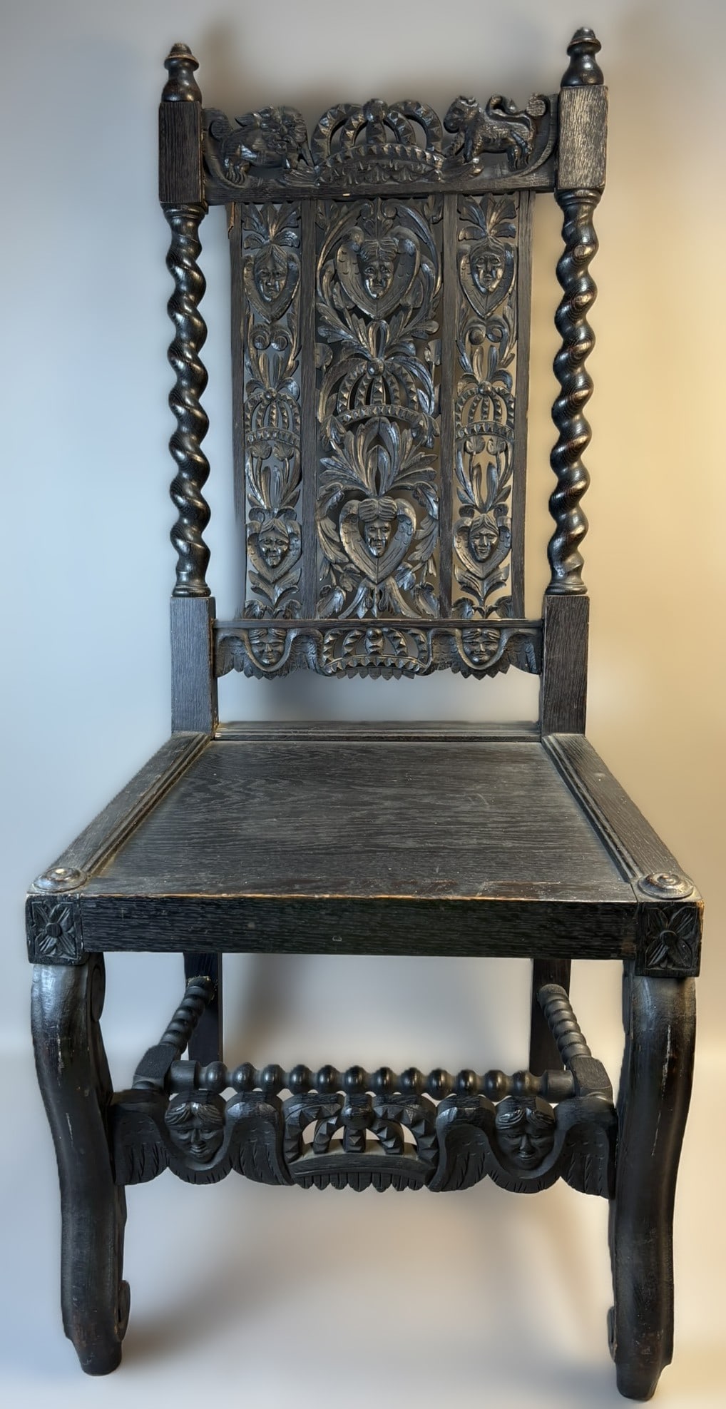 Antique 20th Century Renaissance Revival Carved Oak Side Chair: Striking Renaissance Revival style side chair, likely a 20th century interpretation of an early 19th century design. Executed in dark-stained oak, the chair features boldly carved figural and foliate