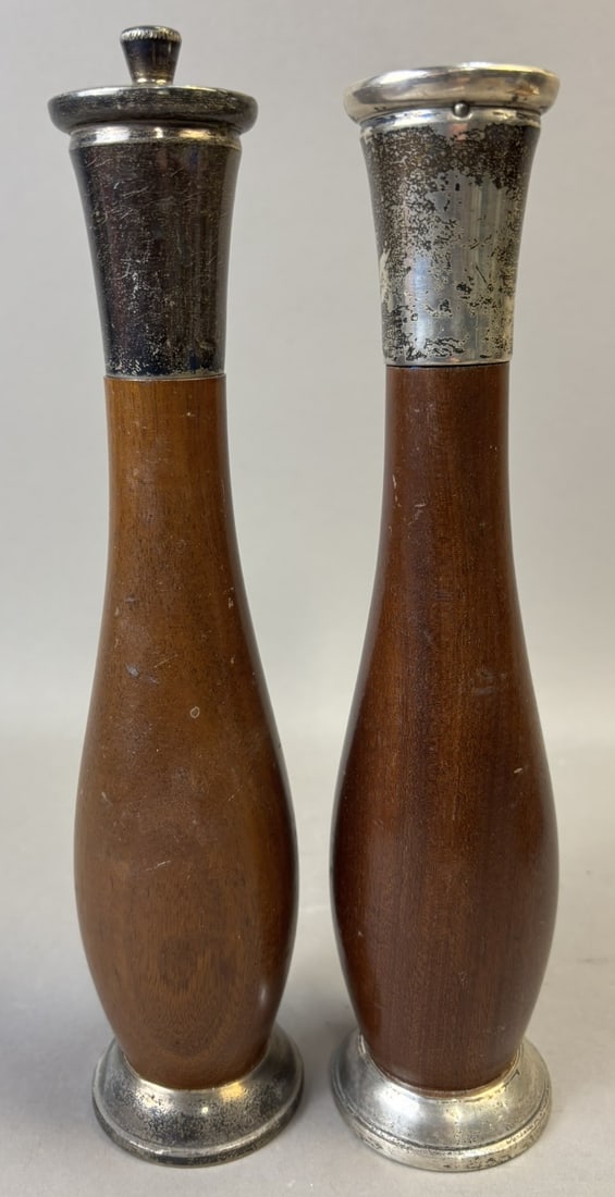 Pair Teak Salt & Pepper Grinders Sterling Silver Mounted 10.5": A handsome pair of vintage teak salt and pepper grinders featuring sterling silver mounts at both the bases and tops. Beautifully turned in a classic mid-century form, these mills showcase rich, warm