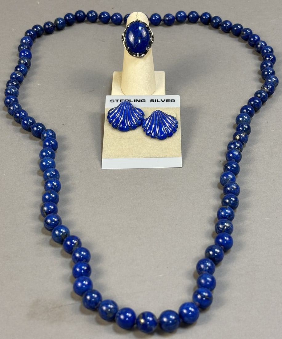 Lapis Lazuli Bead Necklace Sterling Lapis Ring & Lapis Shell Earrings: Coordinated lapis lazuli jewelry group including a single strand lapis bead necklace, sterling silver lapis cabochon ring, and pair of lapis shell form stud earrings marked Sterling Silver. The neckla