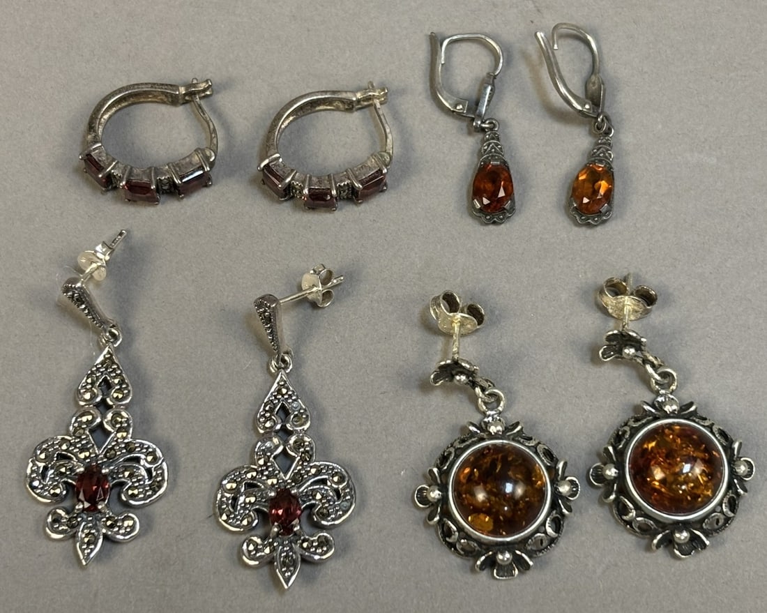 Sterling Silver Amber Garnet Marcasite Earrings Lot 4 Pairs 18.37g: Group of four pairs of sterling silver earrings including Baltic amber drop earrings, garnet set hoop earrings with marcasite accents, garnet and marcasite fleur-de-lis drop earrings marked NF 925 Tha