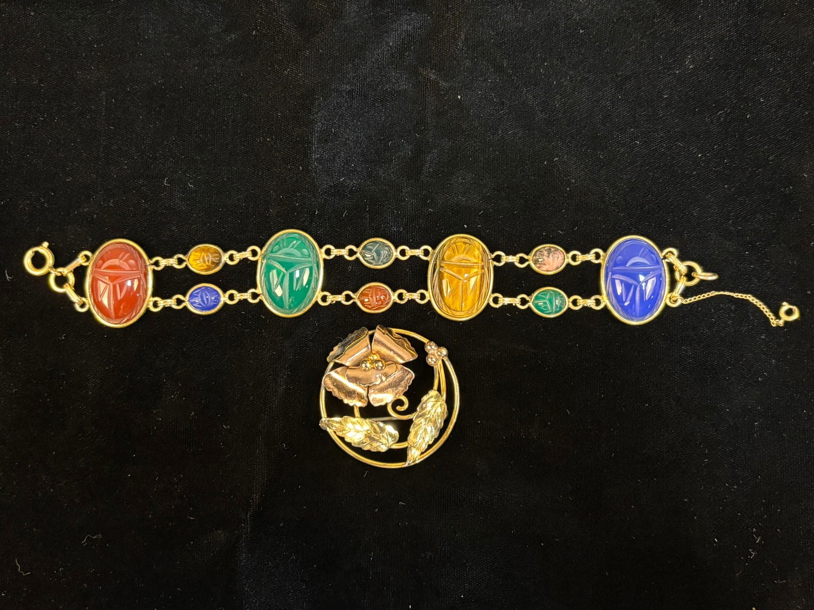 12K Gold Filled Scarab Bracelet & Floral Brooch 1/20 12K GF Pair 43.2 Grams: Vintage 1/20 12K gold filled jewelry set consisting of a colorful Egyptian revival style scarab bracelet and a floral circle brooch. The bracelet features carved scarab style stones in vibrant tones o