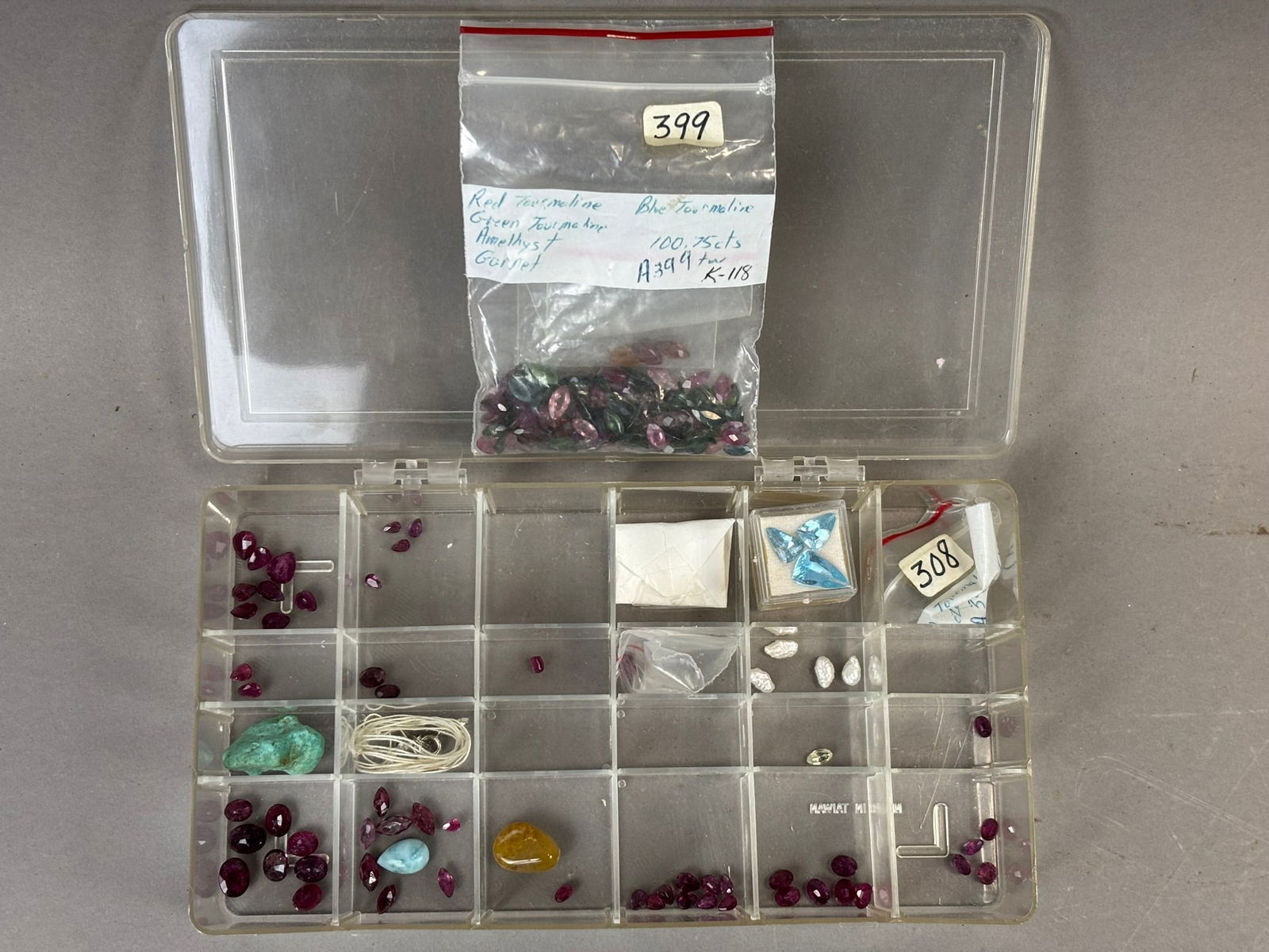 Loose Gemstone Collection Tourmaline Garnet Amethyst Mixed Stones Lot 100+ Carats: Assorted loose gemstone collection housed in a compartmentalized plastic organizer including numerous faceted stones identified on the accompanying bag as red and green tourmaline, blue tourmaline, am