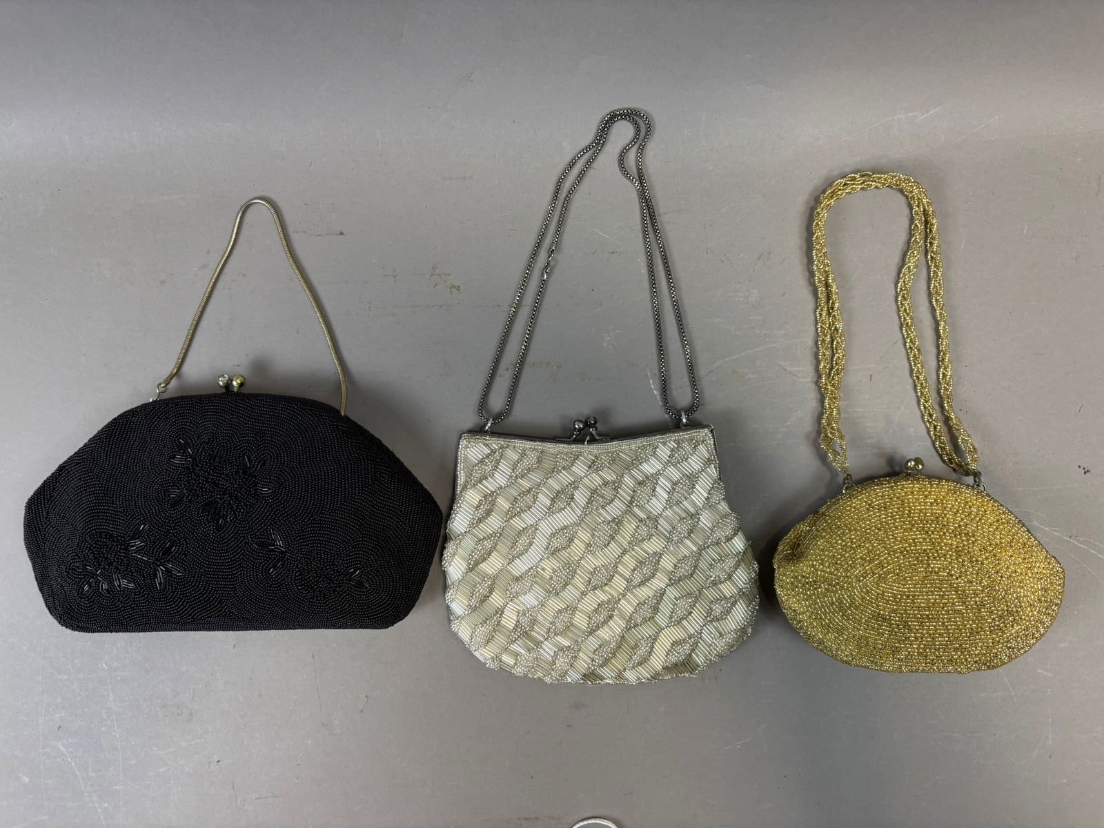 Vintage Beaded Evening Purse Lot Glass Seed Bead Handbags 3pc: Collection of three vintage beaded evening purses including a black glass seed bead clutch with floral beadwork decoration and metal frame clasp, a white beaded handbag featuring alternating rows of s