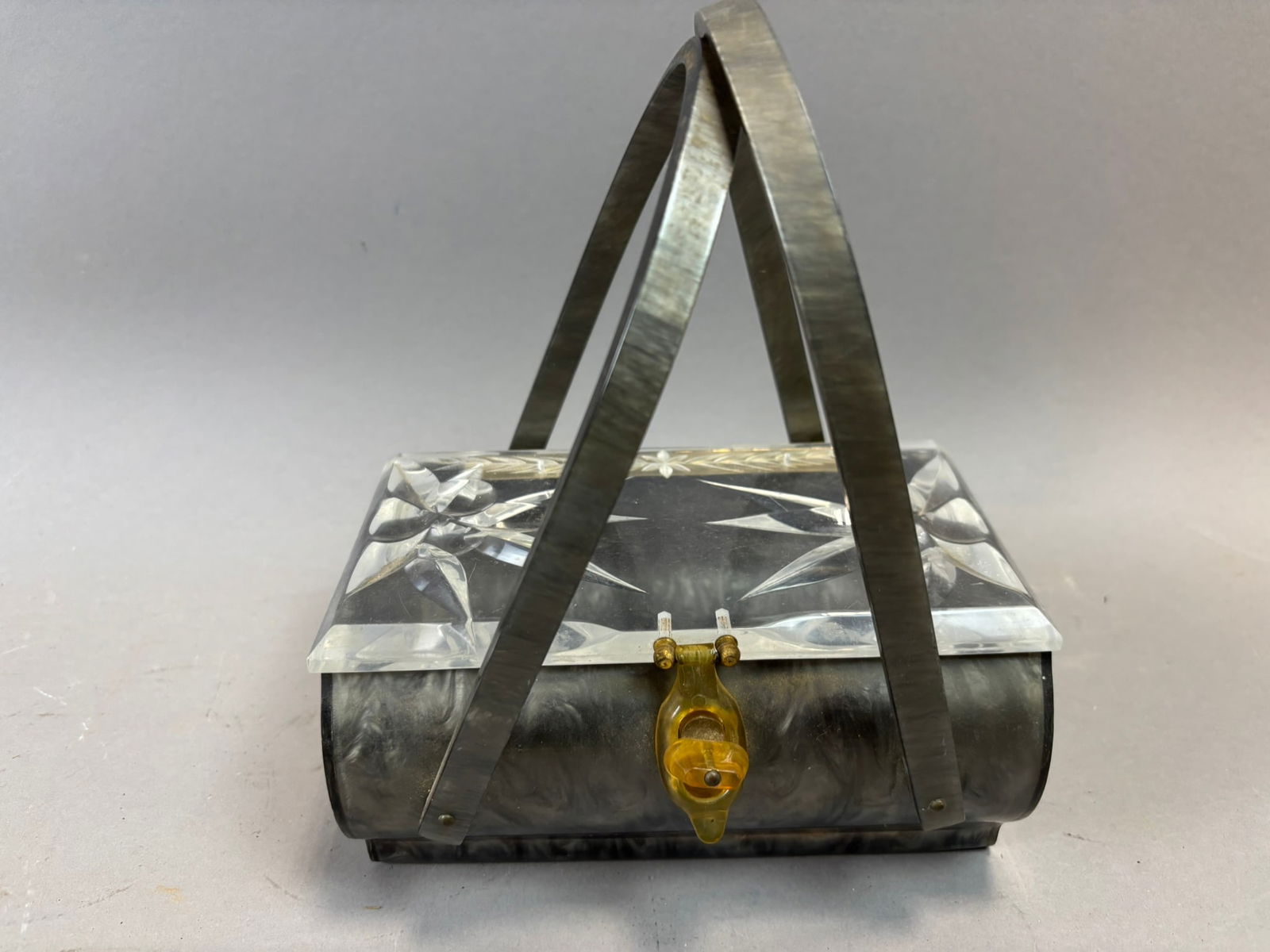 1960s Lucite Box Purse Carved Lid Marbleized Body Top Handle Handbag: Vintage 1960s Lucite box purse featuring a carved clear Lucite lid with geometric starburst style faceting and floral engraving, mounted on a gray marbleized Lucite body. The purse is fitted with rigi