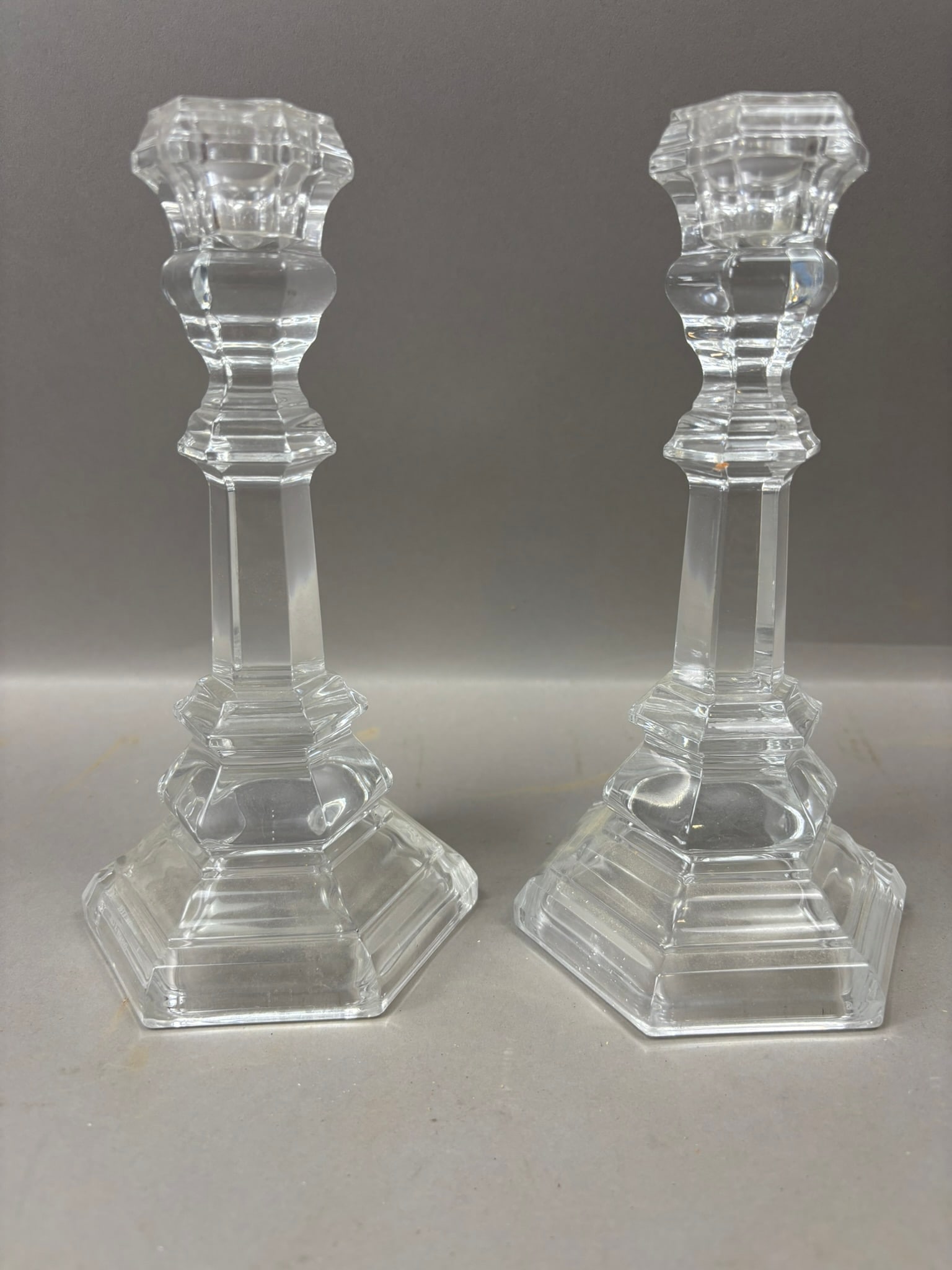 Pair Antique Cut Glass Candlesticks Faceted Crystal Candle Holders 8.25": Pair of antique clear cut glass candlesticks featuring a faceted and stepped design with octagonal base, paneled stem, and molded candle cups, executed in heavy clear glass typical of late 19th to