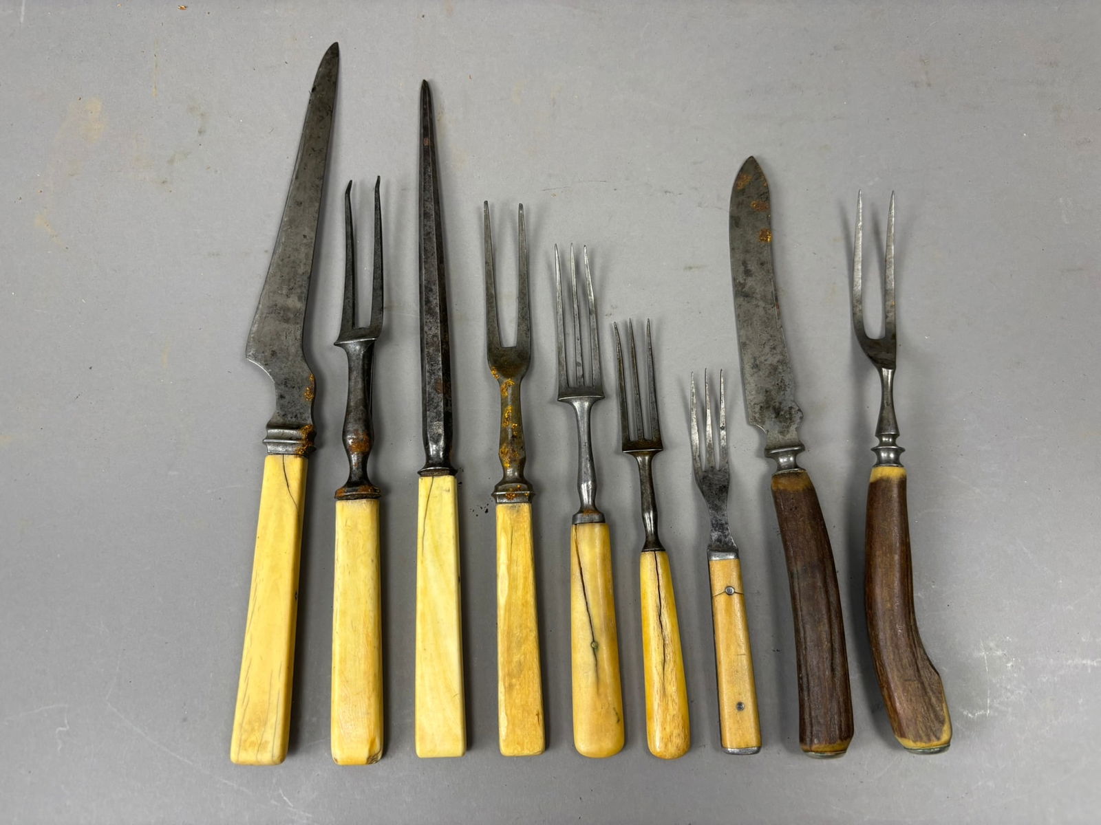 9 Piece Antique Lot 19th Century Carving Knife Fork Set Bone & Wood Handles: Group of nine antique carving and serving utensils including knives and forks with mixed bone and wood handles, measuring approximately 5.75 inches to 12.125 inches in length. The lot includes