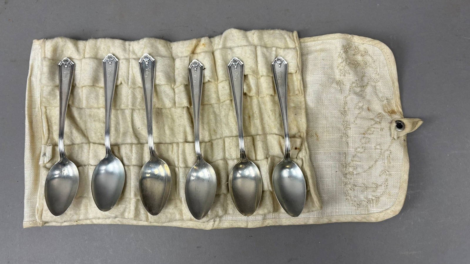 Set 6 Antique Sterling Silver Teaspoons w Roll Case 122g Total: Set of six sterling silver teaspoons presented in their original cloth roll, each bearing a hallmark and stamped STERLING. The spoons feature an elegant classic pattern with fluted handles and a small