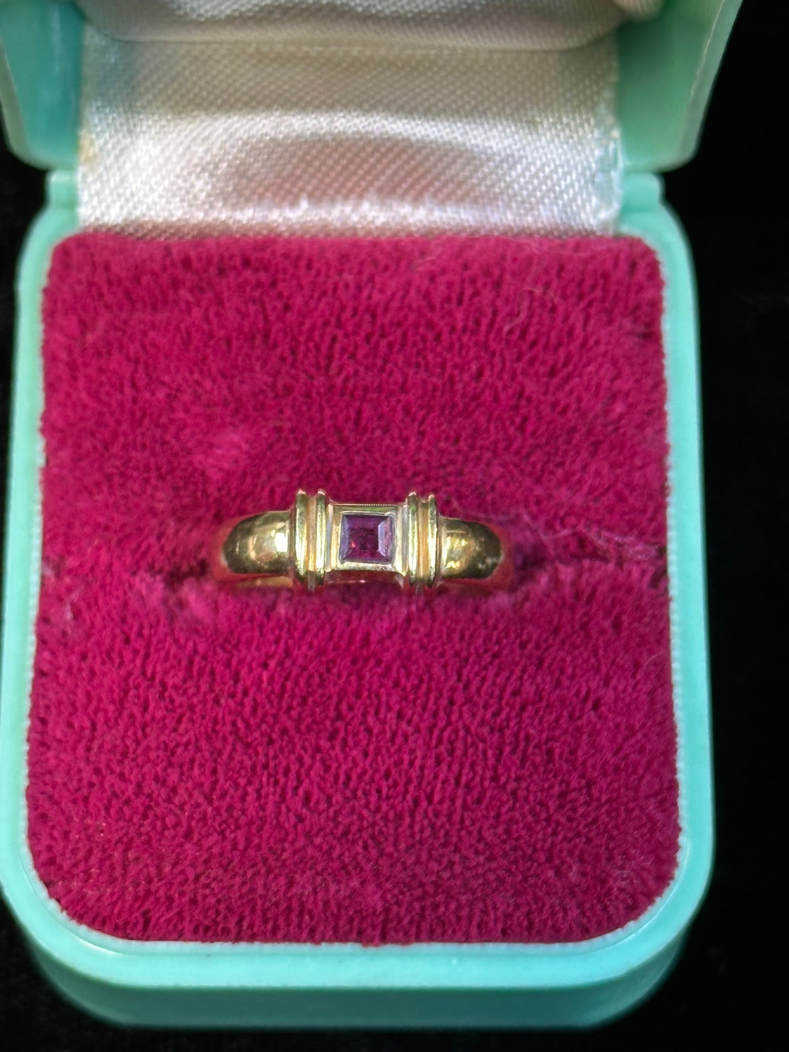 Tiffany & Co 18K Gold Square Ruby Ring Modernist Band 4.62g: Tiffany & Co 18K yellow gold ruby ring featuring a square-cut ruby set within a distinctive modernist mount flab4323ed by fluted gold shoulders and a rounded band, the interior stamped “T&CoR