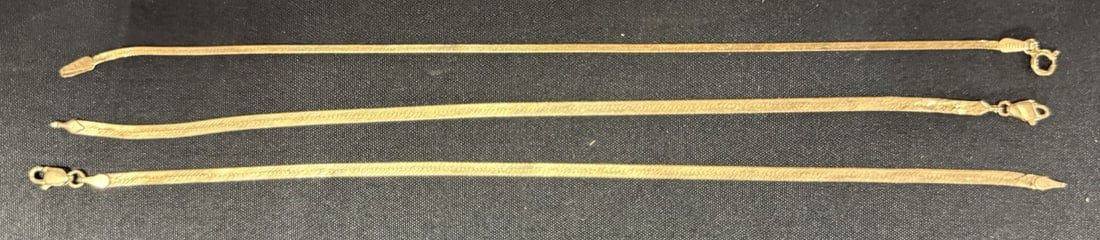 Three 14K Yellow Gold Bracelets Herringbone Styles 7.5" 4.71g: Lot of three 14 karat yellow gold bracelets including two herringbone style chains and one fine chain, each measuring approximately 7.5 inches in overall length. All three bracelets are marked “