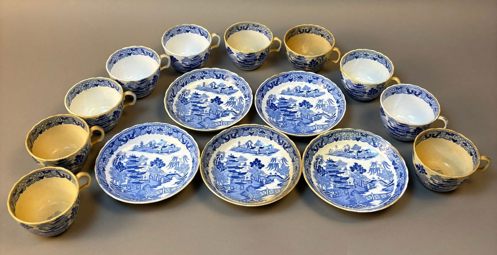 Japanese Blue White Pagoda Landscape Porcelain Tea Set Cups Saucers: Japanese export blue and white porcelain tea service decorated in the Chinese taste with pagoda landscape scenes including bridges, trees, and architectural motifs within patterned borders. The set in
