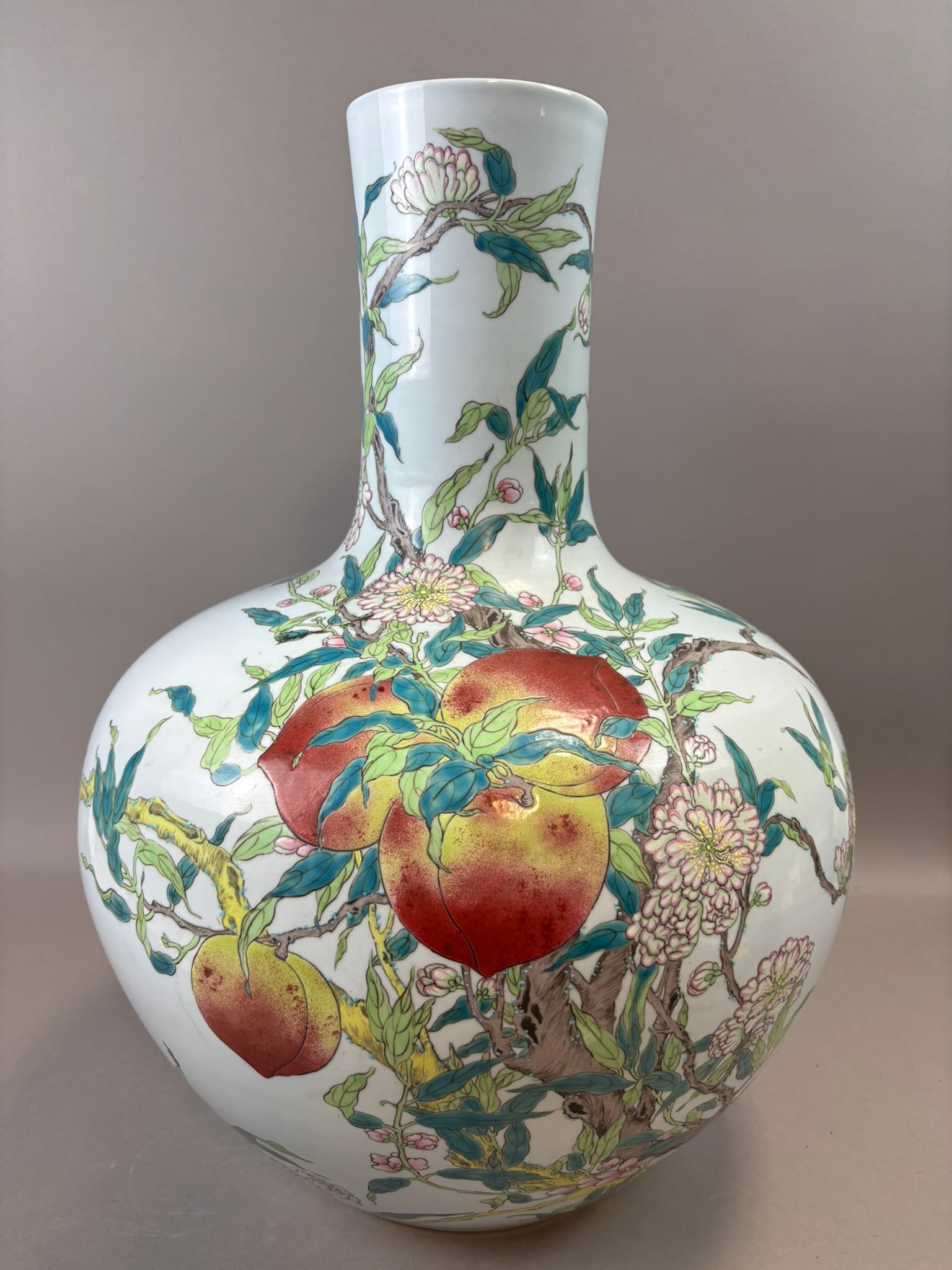 Chinese Famille Rose Longevity Peach Vase Qianlong Mark Late Qing: Chinese porcelain vase of baluster form decorated in finely painted famille rose enamels with flowering branches bearing peaches and chrysanthemums symbolizing longevity and prosperity. The decoration