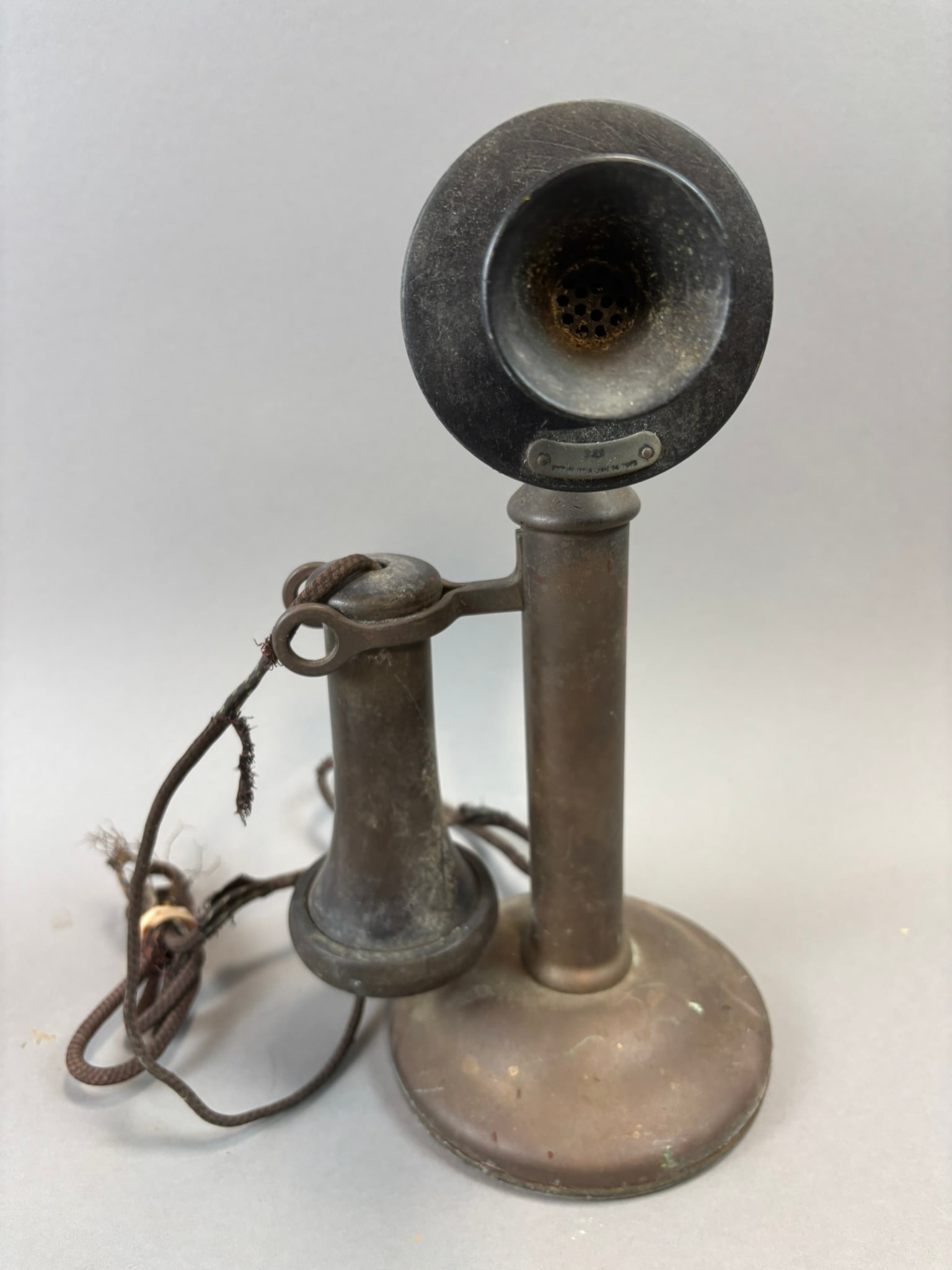 Early Candlestick Telephone Desk Stand Brass Western Electric Style Phone: Early candlestick style desk telephone constructed of brass with separate transmitter and receiver mounted on a pivoting hook arm. The upright column rises from a weighted circular base and supports a