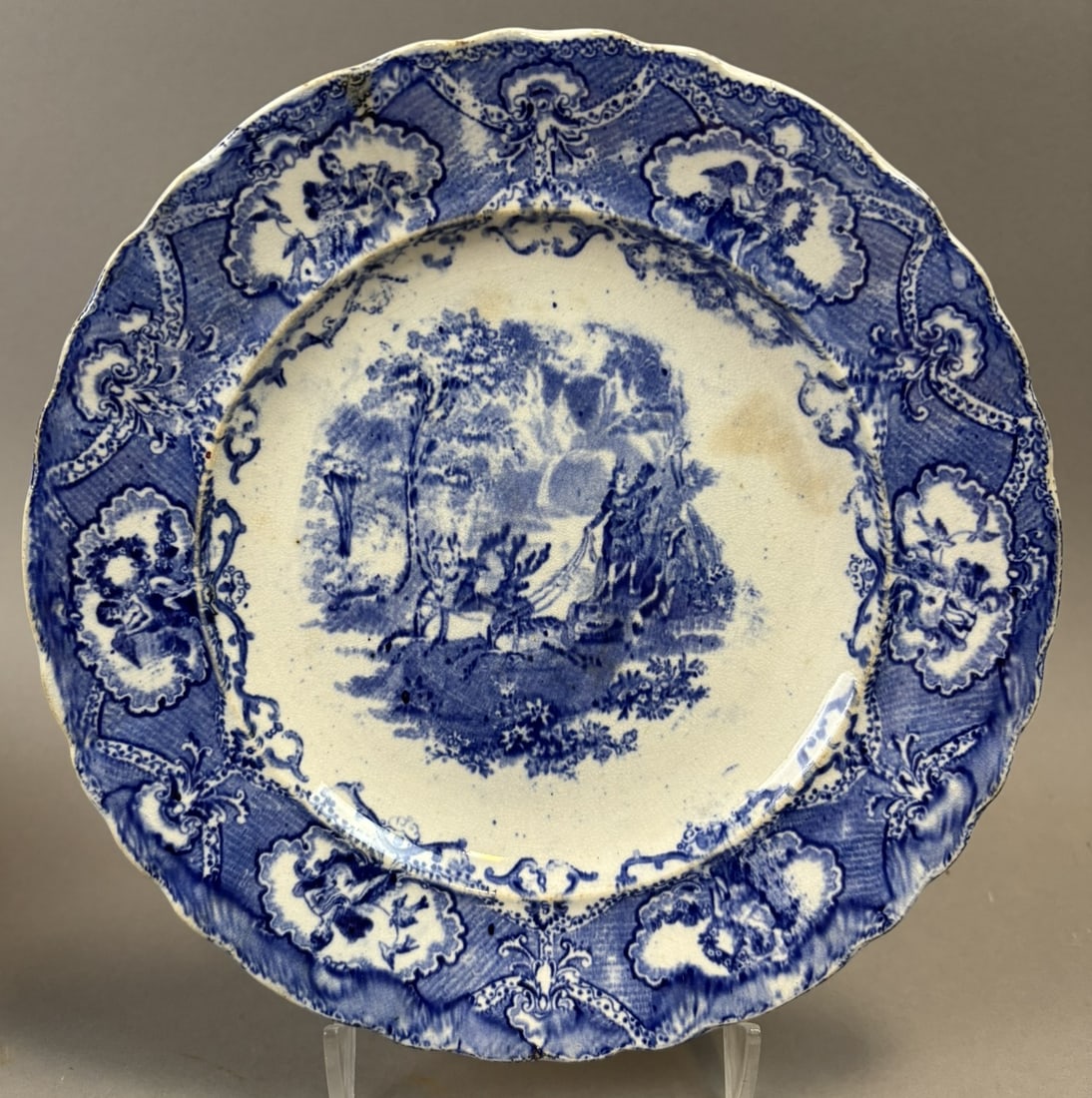 J & W Ridgway Staffordshire Blue Transferware Scenic Plate c1820s: Early 19th century Staffordshire blue transferware plate by J & W Ridgway featuring a romantic scenic landscape with figures beside a draped monument beneath a tree, framed by an ornate molded border