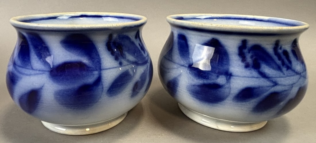 Pair Blue & White Hand Painted Porcelain Salt Cellars Open Salts: Pair of blue and white hand painted porcelain open salt cellars featuring a flowing floral and foliate motif in deep cobalt blue on a white ground. Each small bowl form measures approximately 4 inches