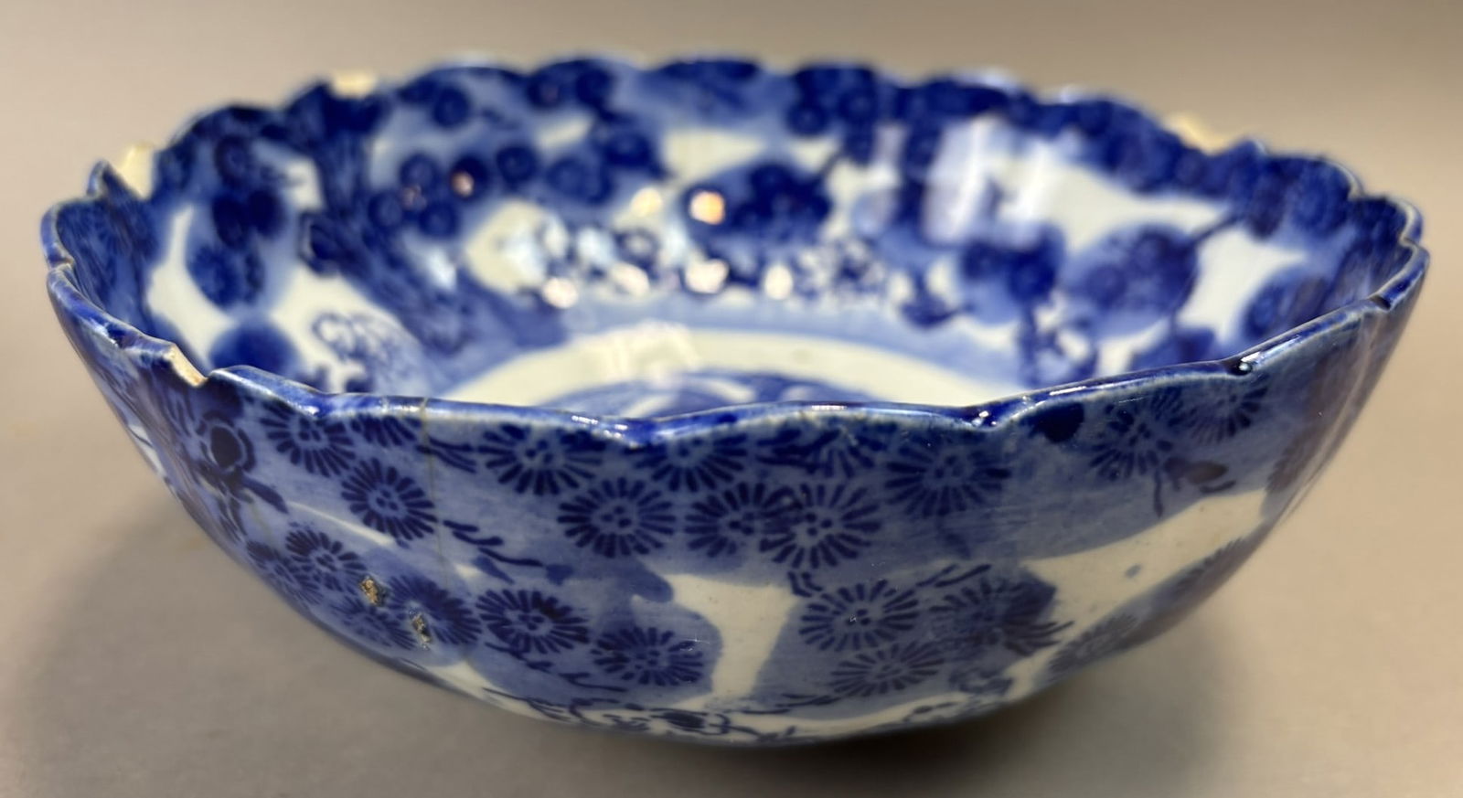 Antique Chinese Export Blue White Porcelain Scalloped Bowl Figural Scene: Antique Chinese blue and white porcelain bowl featuring a scalloped rim and richly detailed transfer decoration including stylized chrysanthemum blossoms, landscape elements, and figural scenes surrou