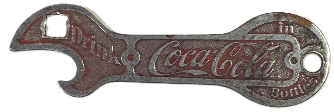 Antique Coca-Cola Key Chain Bottle Opener w/ Original Paint Rare: Vintage Coca-Cola bottle opener featuring the iconic 'Drink Coca-Cola in Bottles' slogan. Constructed from metal with red painted accents highlighting the embossed lettering and design. The opener inc