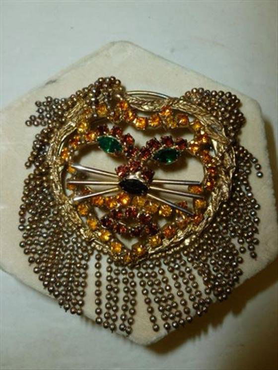 Large unmarked lion brooch: Large unmarked lion brooch gold green rhinestones 3 1/2 long 3 dia hanging gold tone beads this is a great Piece don't miss it