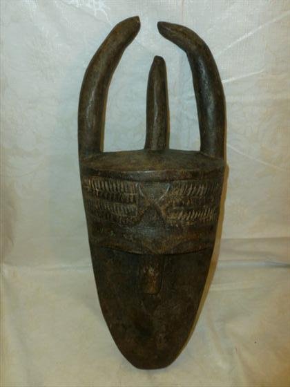 Roma Tribe Poro Mask- carved wood stain black with flat: Roma Tribe Poro Mask- carved wood stain black with flat oval face tiny pierced eyes 3 carved horns pierced around the rim 16"-