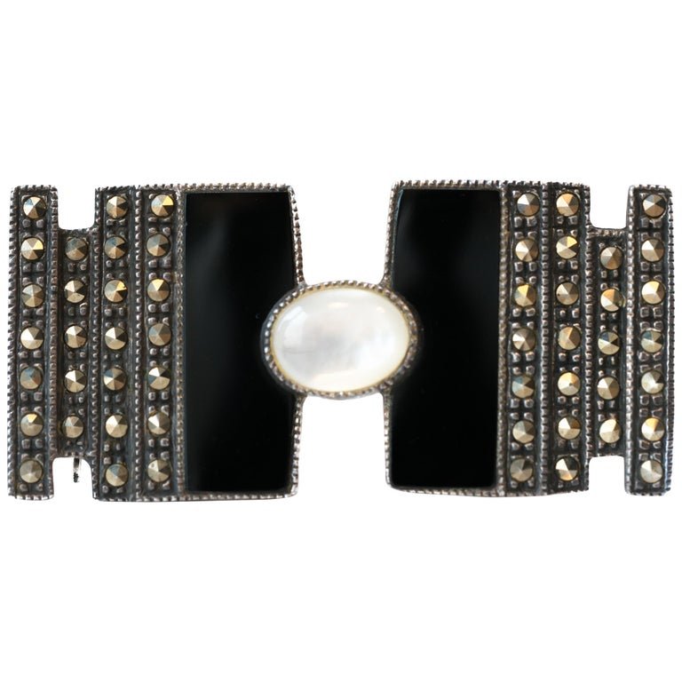 Onyx, Marcasite and Mother of Pearl Sterling Silver Brooch: Art Deco-Inspired Brooch - Sterling Silver, Marcasite, Onyx, Mother of PearlFeatures:Art Deco-Inspired DesignH-shape Design8 Vertical Rows of sparkling Marcasite 2 Vertical Bands of inky Black Onyx in
