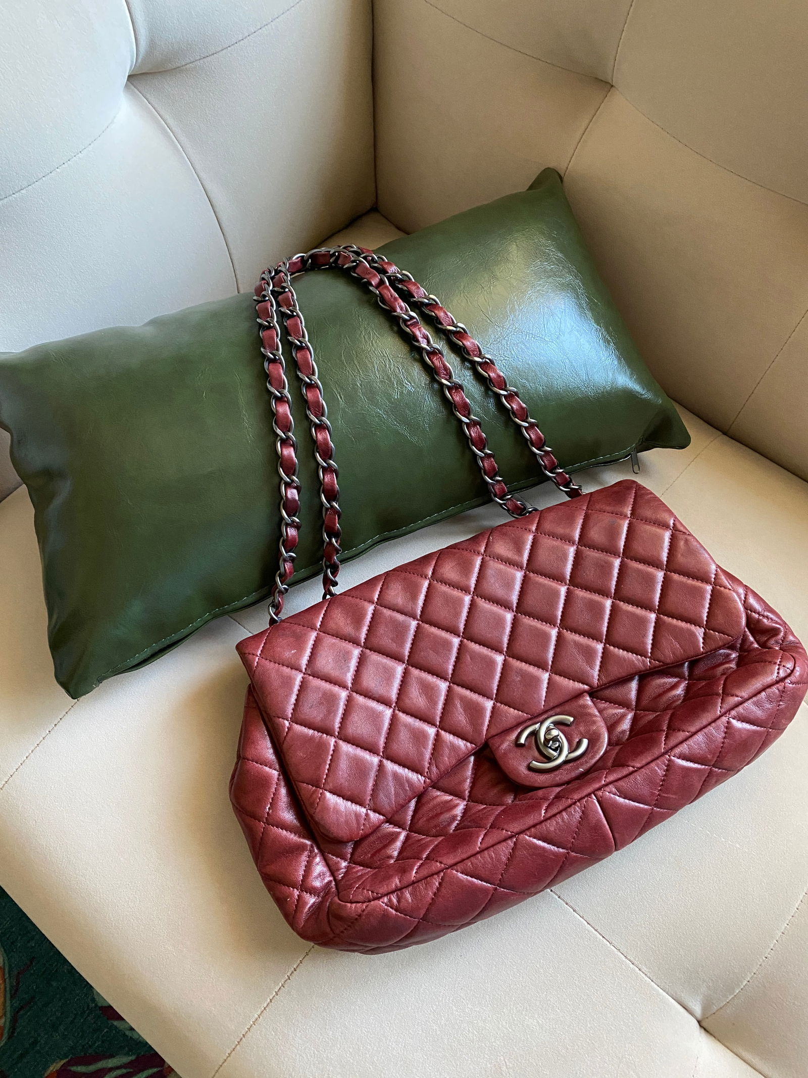 Chanel Burgundy Flap Bag: Chanel lambskin classic flap bag in burgundy, 5.5"H x 12"W. Pre-owned in acceptable condition with some wear on the outside and staining on interior.