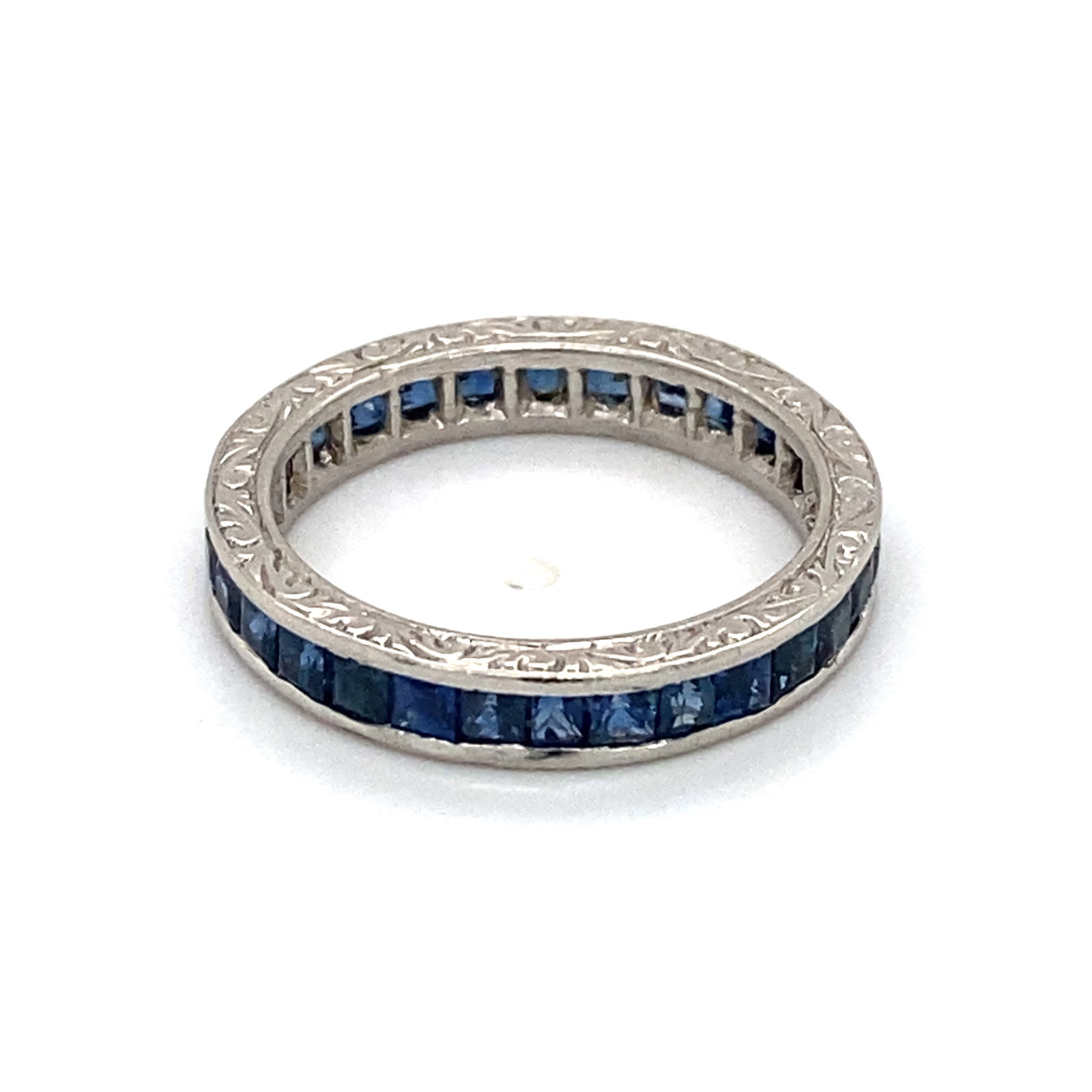 1940s Sapphire Eternity Band: Platinum 1940s eternity band with ornate detailing on edge, with French cut blue sapphires at 2.0 carat total weight. Size 6.25, 4.7g