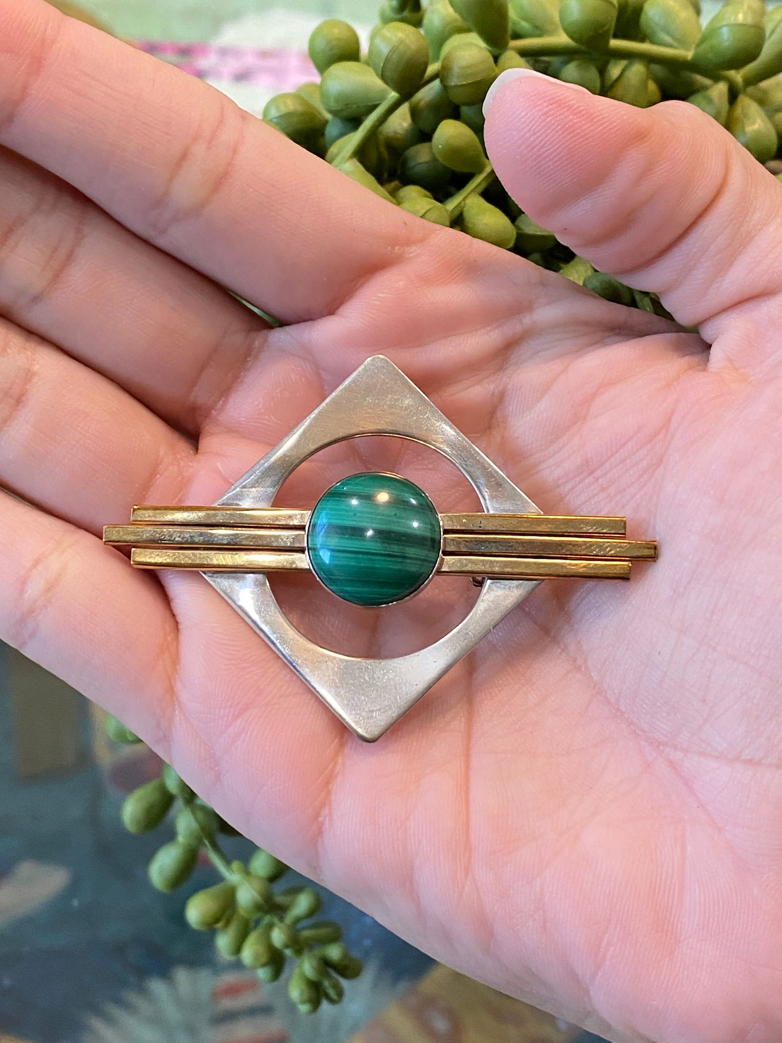 Circa 1950s Malachite Geometric Brooch in Sterling Silver and 18 Karat Gold: Circa: 1950, Metal type: Sterling Silver and 18K Yellow Gold, Gemstone: Malachite, Dimensions: 2.25 inches long x 1.75 inches wide, Weight: 11.5 g
