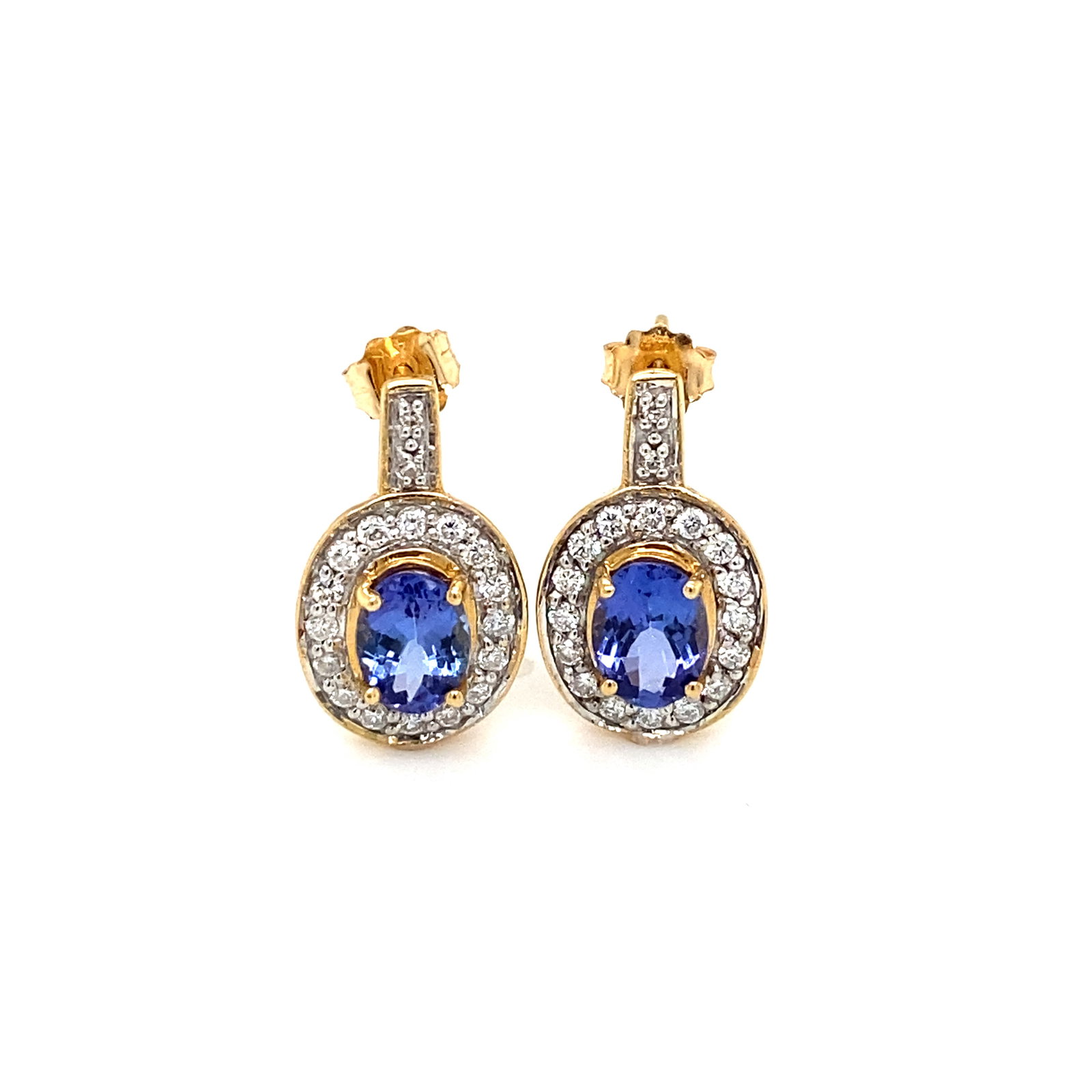 Oval Tanzanite and Diamond Earrings: 18k gold earrings with oval tanzanites 1.50ctw and round diamonds approximately 0.50ctw. 0.50"L, 4.4g. These earrings have post backs and are stamped with a maker's mark TG.