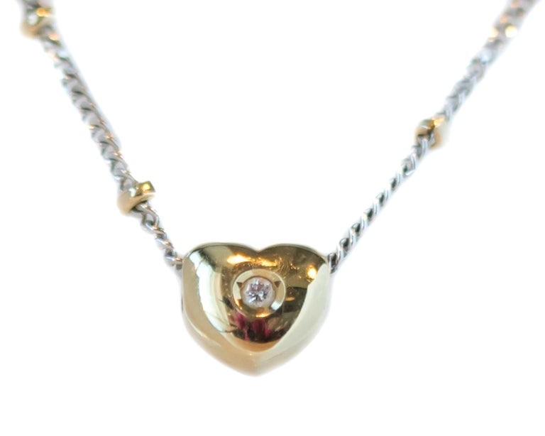 1970s 14 Karat Gold Two-Tone Puffed Heart Necklace: Circa 1970s, 14 karat yellow and white gold necklace with puffed heart pendant and accent diamond. 18"L, 3.0 grams.