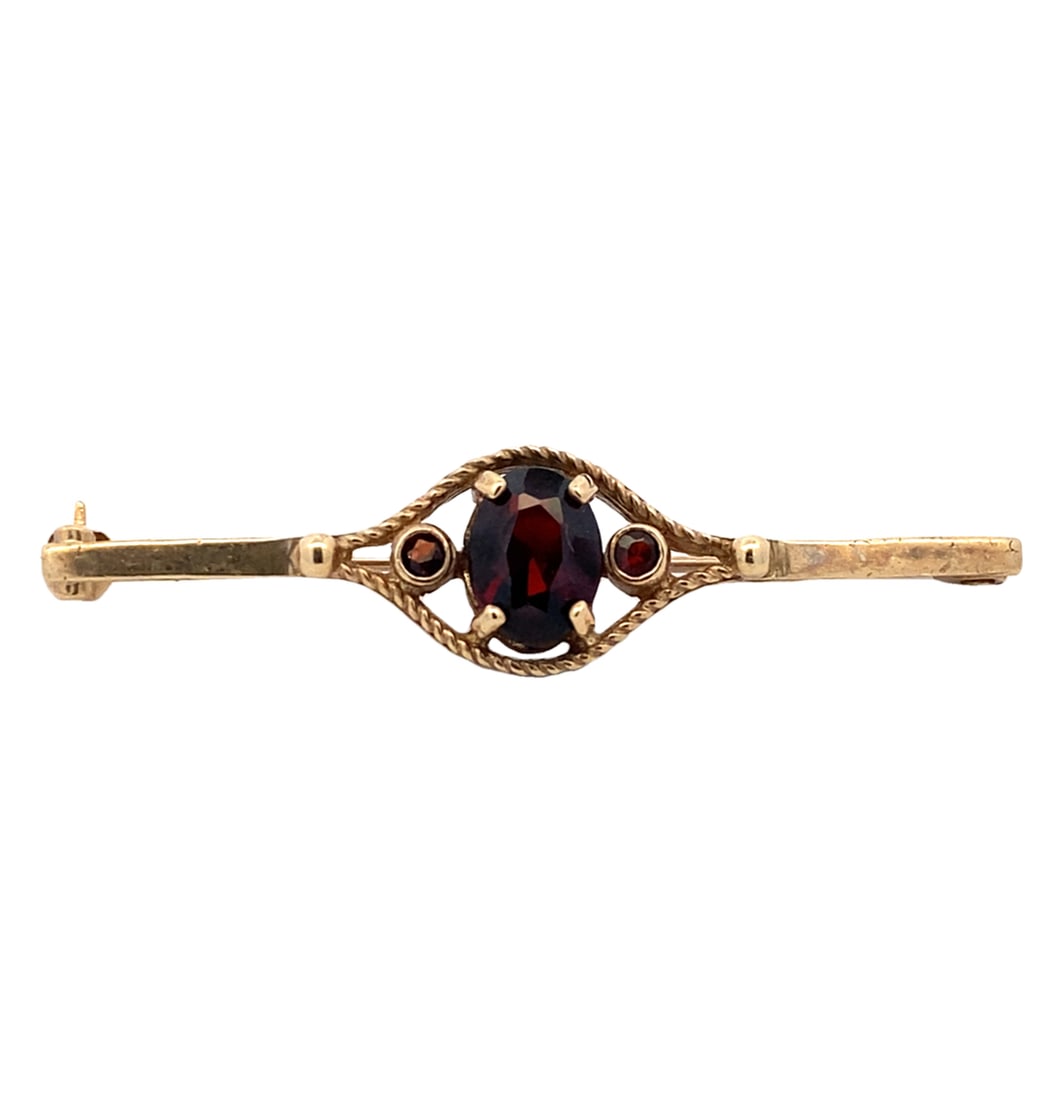 Estate Garnet Brooch in 9K Yellow Gold: Estate, Metal type: 9k yellow gold English Hallmarked, Stone: Garnet - 6 mm L x 8 mm H center stone, Measurement: 1.75: Length, Weight: 2.4 grams