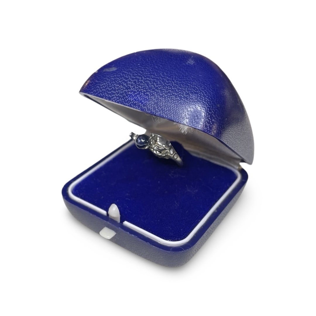 Old White Metal Diamond and Saphire Ring with Original Box: Old white metal diamond and saphire ring in its original box. Diamonds are tested. Please see pic. #6. The ring's design depicts a bear reaching for the saphire. Combined shipping is available for thi