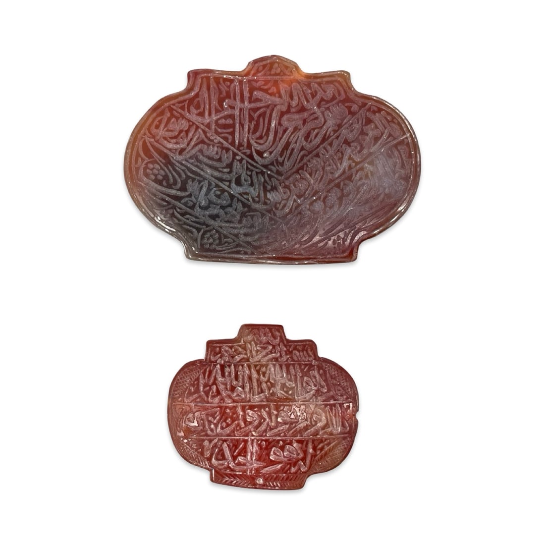 A Group of Two Hand-Carved Islamic Red Carnelian Agate (Yemeni Aqeeq) Talismanic Plaques, in: A Group of Two Hand-Carved Islamic Red Carnelian Agate (Yemeni Aqeeq) Talismanic Plaques, in Traditional Scalloped Cartouche Forms. This appealing auction lot features a matched pair of horizontally o
