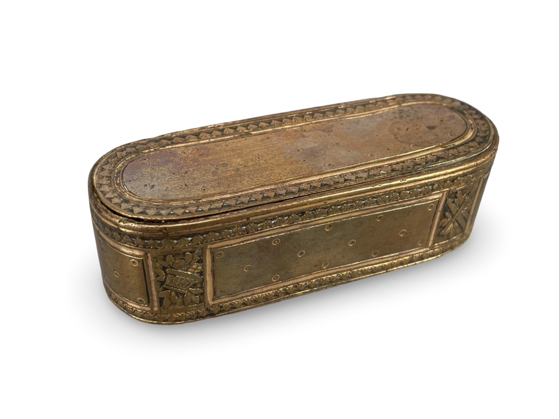 An Antique French Louis XVI Style Gilt Bronze Snuff Box, Featuring Finely Chased Trophies of Arms: An Antique French Louis XVI Style Gilt Bronze Snuff Box, Featuring Finely Chased Trophies of Arms and Engine-Turned Wave Panels. This elegant elongated oval snuff box stands as a refined example of Fr