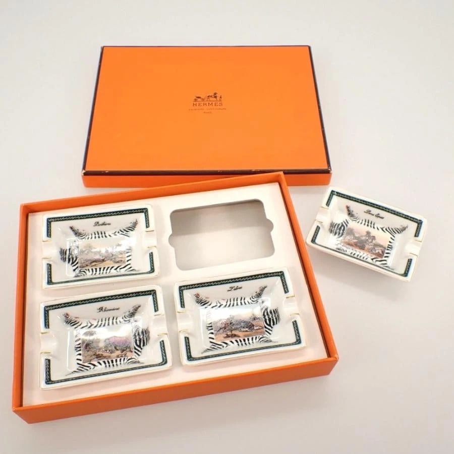 Hermès Mini Porcelain Zebra African Safari Ashtrays (Set of 4) in Original Box: Hermès Mini Porcelain Zebra African Safari Ashtrays (Set of 4) in Original Box. Hermès Mini Porcelain Zebra Trinket trays are in an African Safari design. These are porcelain made in France and each