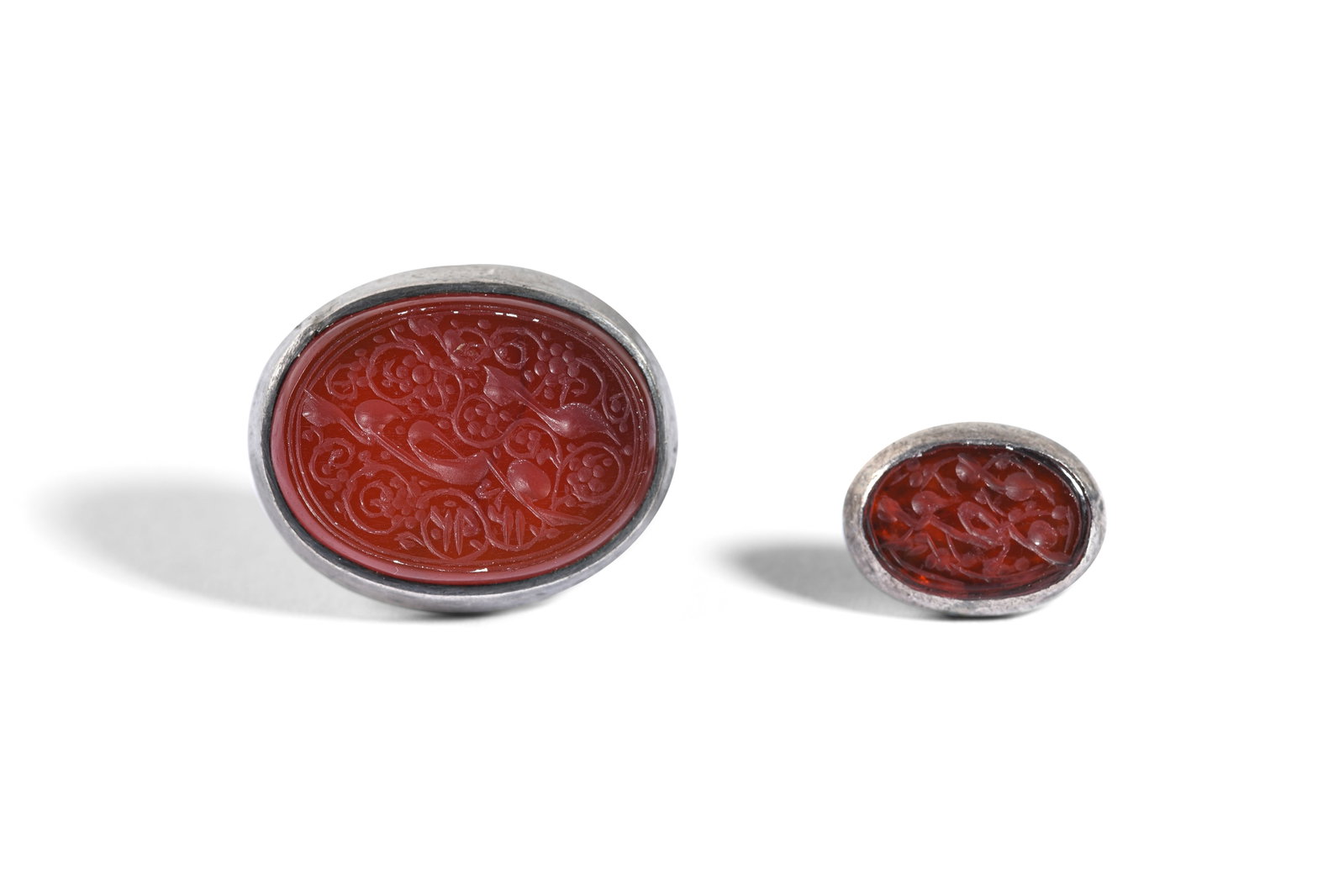 TWO MOUNTED QAJAR NOMINAL SEALS WITH WOMAN'S NAME Qajar Iran, one dated 1292 AH (1875 AD): TWO MOUNTED QAJAR NOMINAL SEALS WITH WOMAN'S NAME PROPERTY FROM A PRIVATE GLYPTOLOGY COLLECTOR Qajar Iran, one dated 1292 AH (1875 AD) Each of oval shape, table-cut, made of red carnelian, set in a lo
