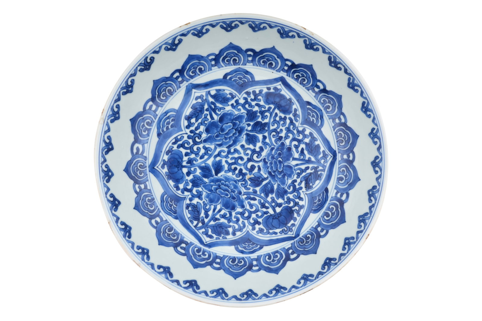 A LARGE CHINESE BLUE AND WHITE ‘PEONIES’ DISH Kangxi period: " A LARGE CHINESE BLUE AND WHITE ‘PEONIES’ DISH Kangxi period With deep sides, decorated with a concentric design of stylised blossoms and ruyi-heads, the reverse with clouds and precious o