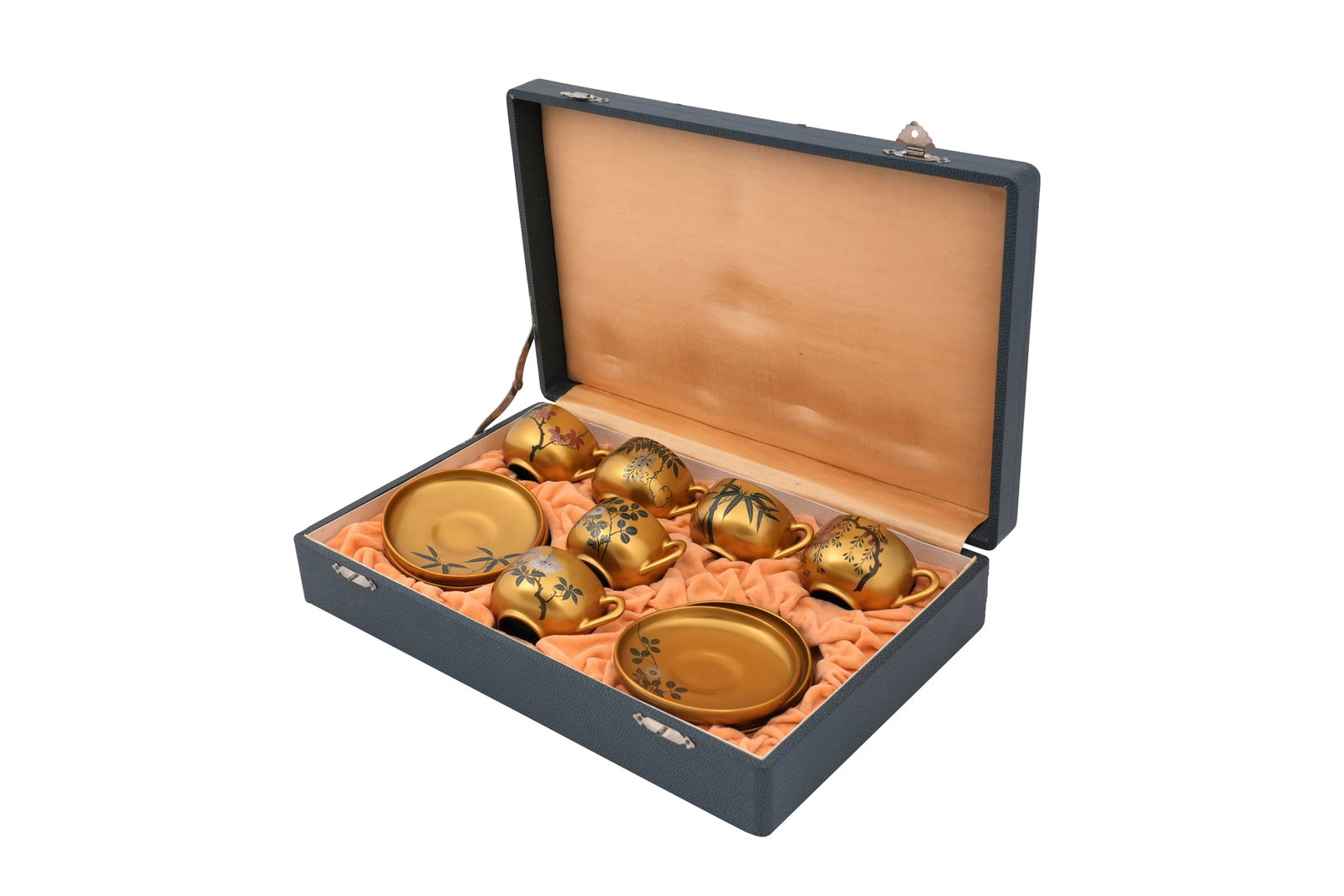 A JAPANESE SIX-PART GILT LACQUER TEA SET Circa 1960: A JAPANESE SIX-PART GILT LACQUER TEA SET Circa 1960 Comprising three cups and saucers painted with various plants, contained in a custom made box and a rectangular tray with plain gilt surface 39.5cm 