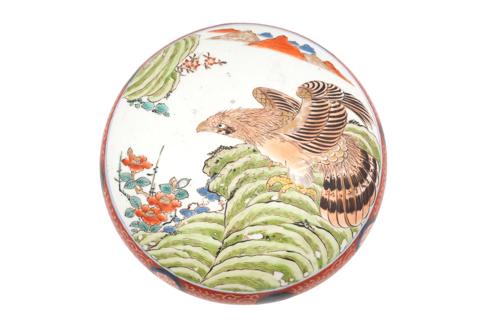 A JAPANESE IMARI CIRCULAR 'EAGLE' BOX AND COVER Meiji period: A JAPANESE IMARI CIRCULAR 'EAGLE' BOX AND COVER Meiji period Painted to the domed cover with an eagle perched on a green rock in a wild landscape, the rims with an iron-red and blue floral band, the f