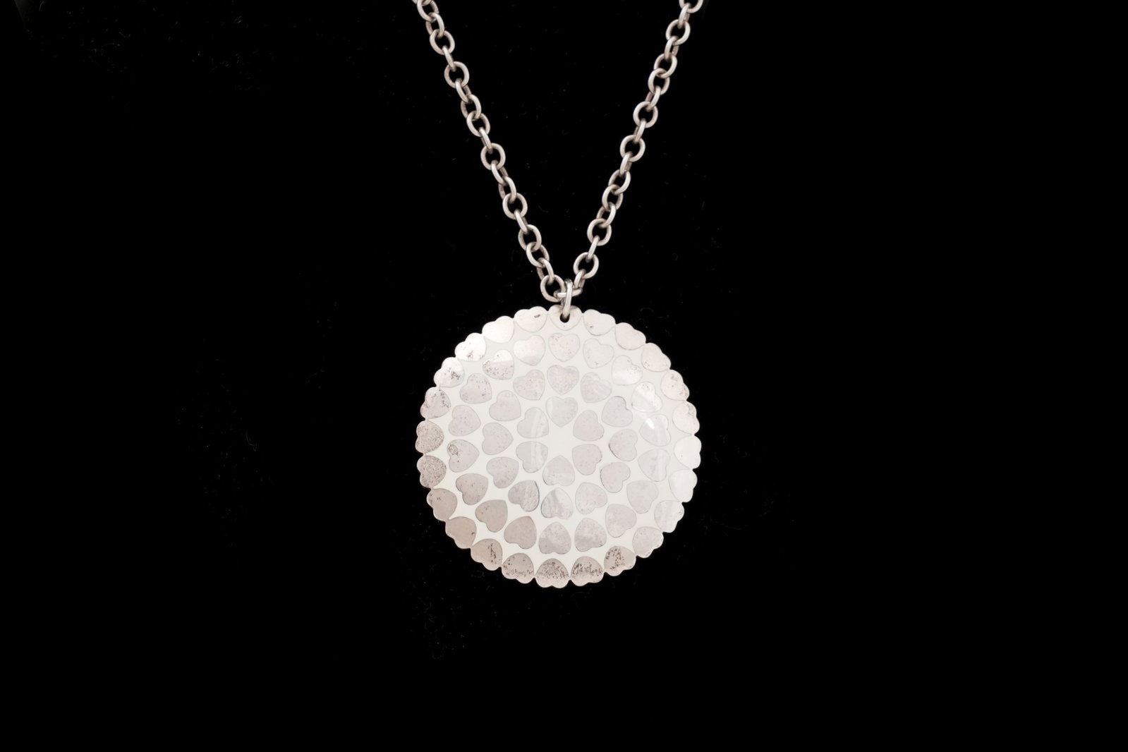 A TIFFANY & CO. STERLING SILVER HEART MOTIF DISC PENDANT NECKLACE 925: A TIFFANY & CO. STERLING SILVER HEART MOTIF DISC PENDANT NECKLACE New York, USA, c.2009 A contemporary Tiffany & Co. sterling silver necklace, the fine chai