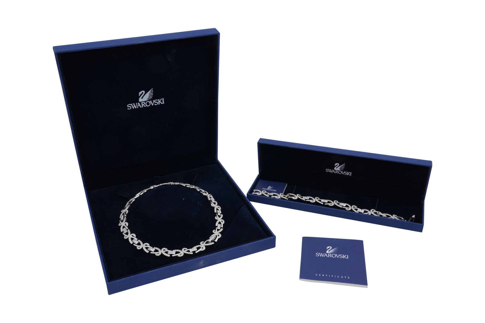 A BOXED SWAROVSKI CRYSTAL IRENE COLLIER NECKLACE AND BRACELET SUITE: A BOXED SWAROVSKI CRYSTAL IRENE COLLIER NECKLACE AND BRACELET SUITE Both of white metal and white crystal, matching in design with swooping scrollwork, segmented by channel set links, both marked Swar
