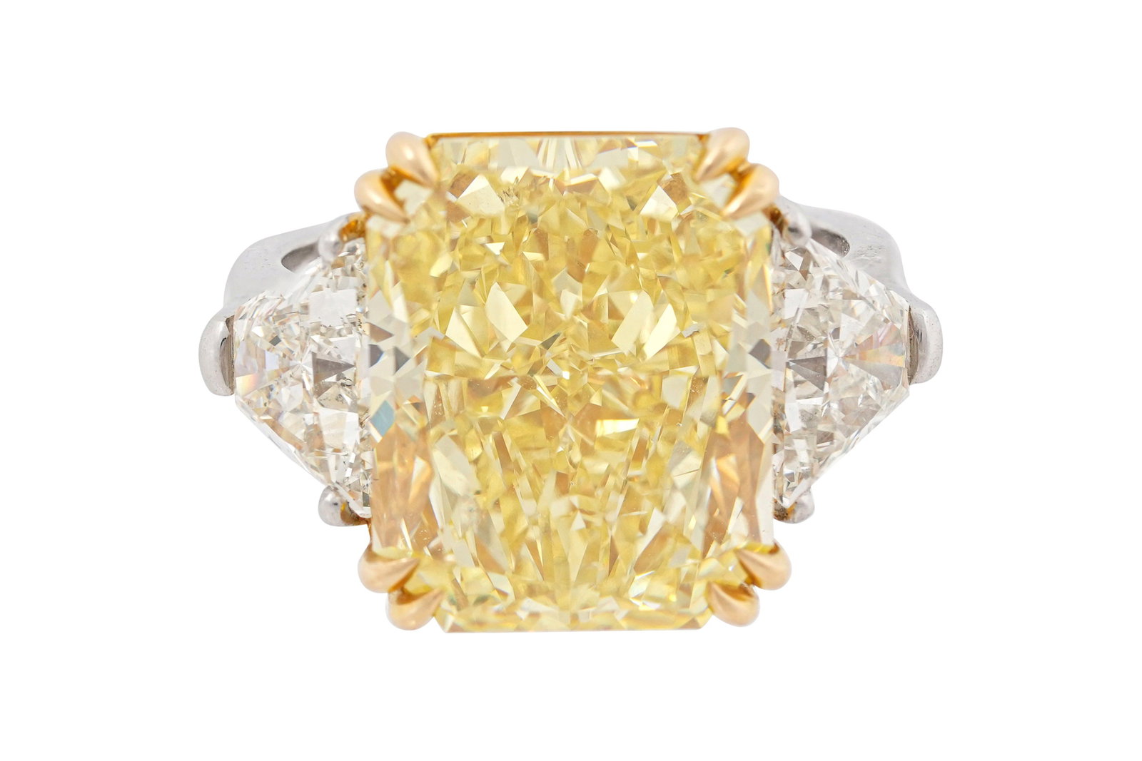 A FANCY INTENSE YELLOW DIAMOND AND DIAMOND RING: A FANCY INTENSE YELLOW DIAMOND AND DIAMOND RING Set with a cut-cornered rectangular modified brilliant cut fancy intense yellow diamond weghing 12.06 carats, flanked with trapezoidal colourless diamon