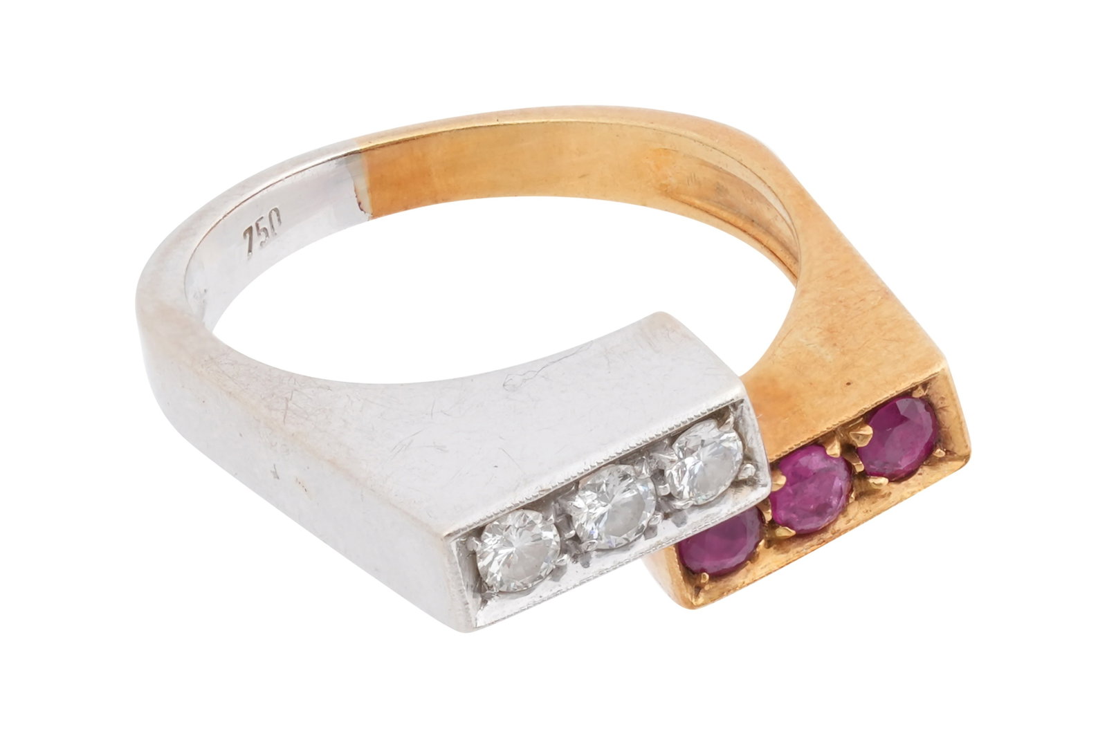 AN 18CT BICOLOUR WHITE AND YELLOW GOLD RUBIES AND DIAMONDS RING: AN 18CT BICOLOUR WHITE AND YELLOW GOLD RUBIES AND DIAMONDS RING With three roundcut rubies of approximately 0.06 carats each, prong set with a milgrain boarder to a rectangular setting in yellow gold,
