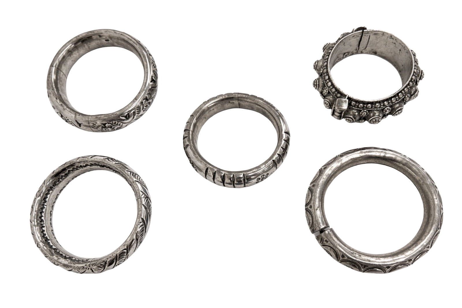 A COLLECTION OF RIGID INDIAN SILVER BRACELETS AND BANGLES (FIVE) India, late 20th century: A COLLECTION OF RIGID INDIAN SILVER BRACELETS AND BANGLES (FIVE) India, late 20th century A group comprising five rigid Indian silver metal bangles of varying widths and weights, with engraved foliate